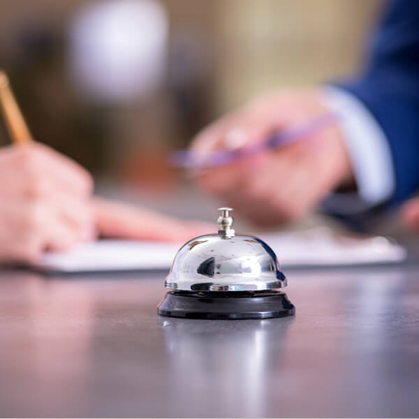 campanello da tavolo in metallo lucido posato sul banco della reception dell'hotel
