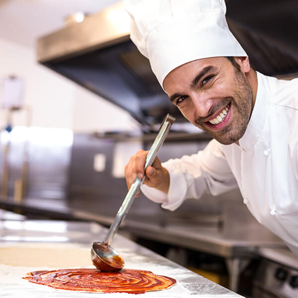 pizzaiolo che sta preparando le pizze per i clienti che hanno prenotato un tavolo nel suo locale tramite il sito web per ristorante
