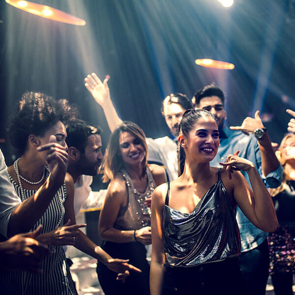 ragazzi che si divertono ballando in discoteca dopo aver scelto il locale perché hanno visitato il suo sito web