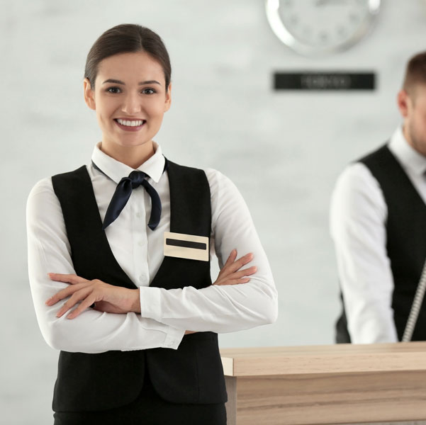 ragazza sorridente che accoglie gli ospiti dell'albergo