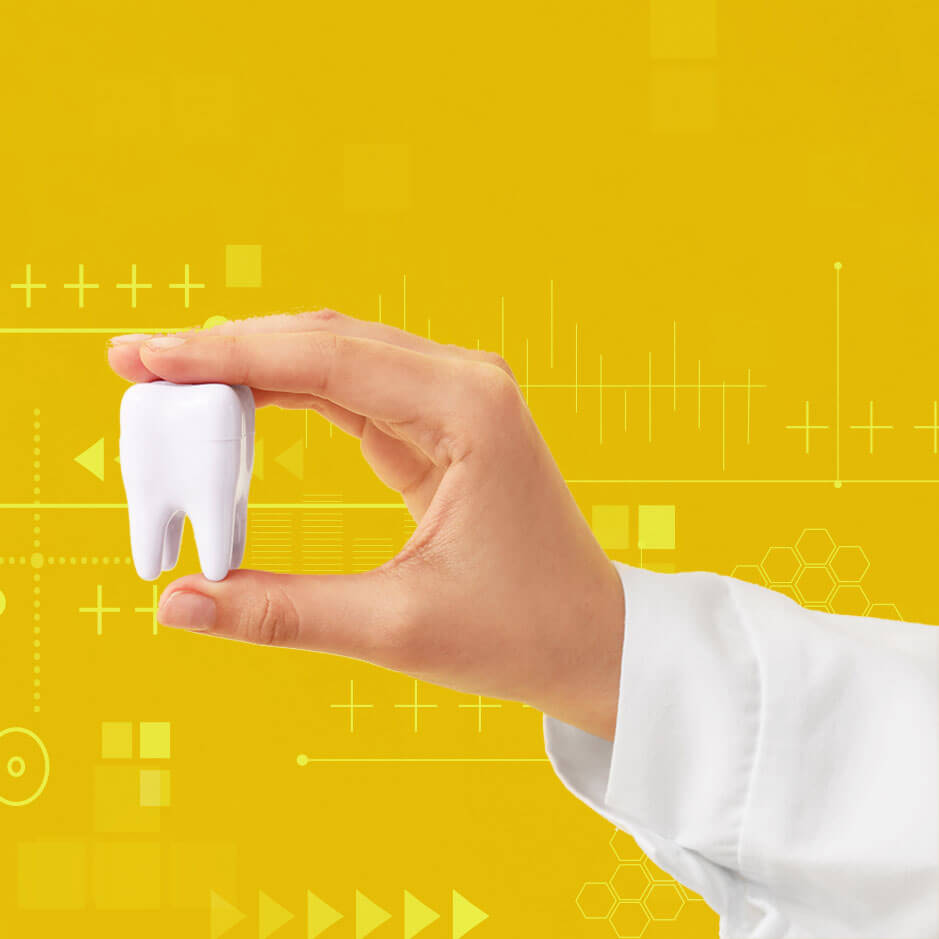 mano di un dentista che fa vedere un oggetto a forma di dente