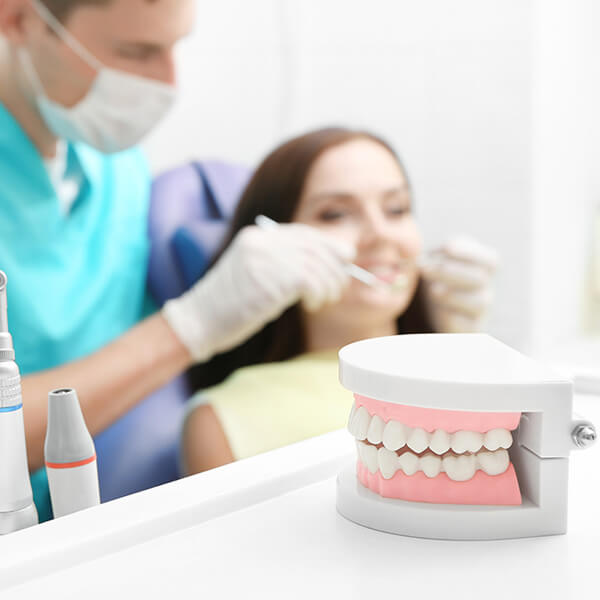 odontoiatra che sta controllando i denti della sua paziente